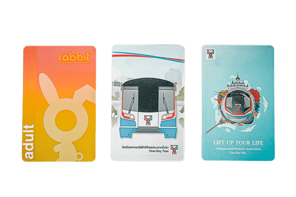 A photo of three types of BTS Skytrain tickets there is a one-day tourist pass, a Rabbit Card nd a single journey Skytrain ticket