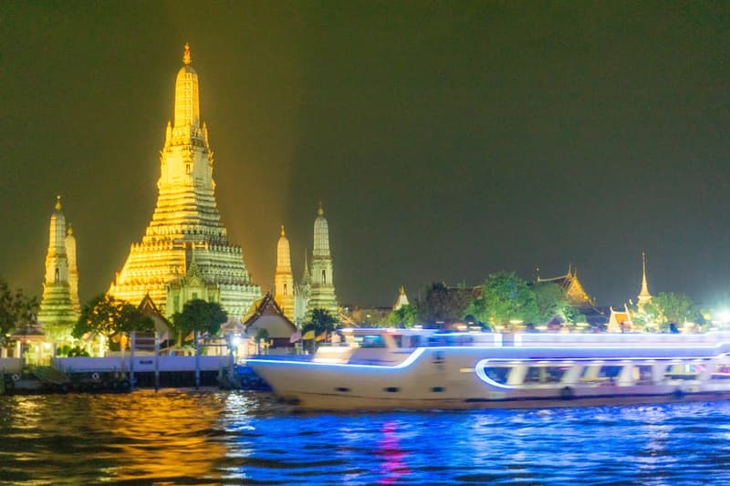 wat arun seen from the bangkok dinner cruise with boat passing by