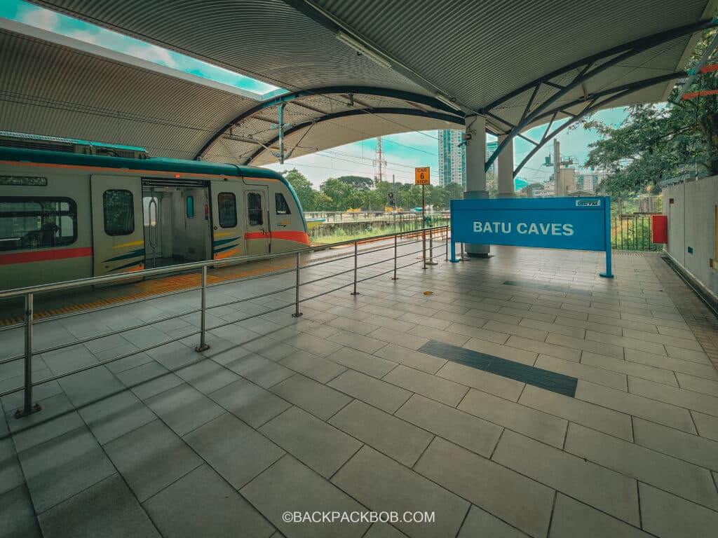 The Batu Caves Train Station The KTM Line Train Has just arrived and is stopped on the platform, you can see the batu caves sign on the platform which is big and blue