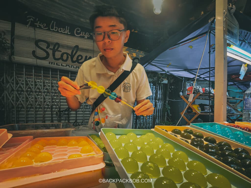 A young Malaysian vendor sells sweets and candy at Jonkers Market Jonkers Street Market | Jonkers Street Weekend Market | Jonkers Street Night Market | Jonkers Street Market in Melaka