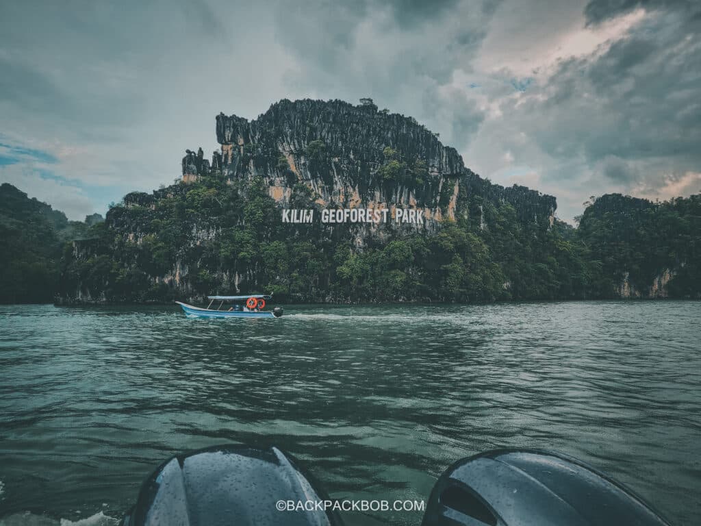 A small boat takes tourists to see the kalim goeforest park sign on a tour