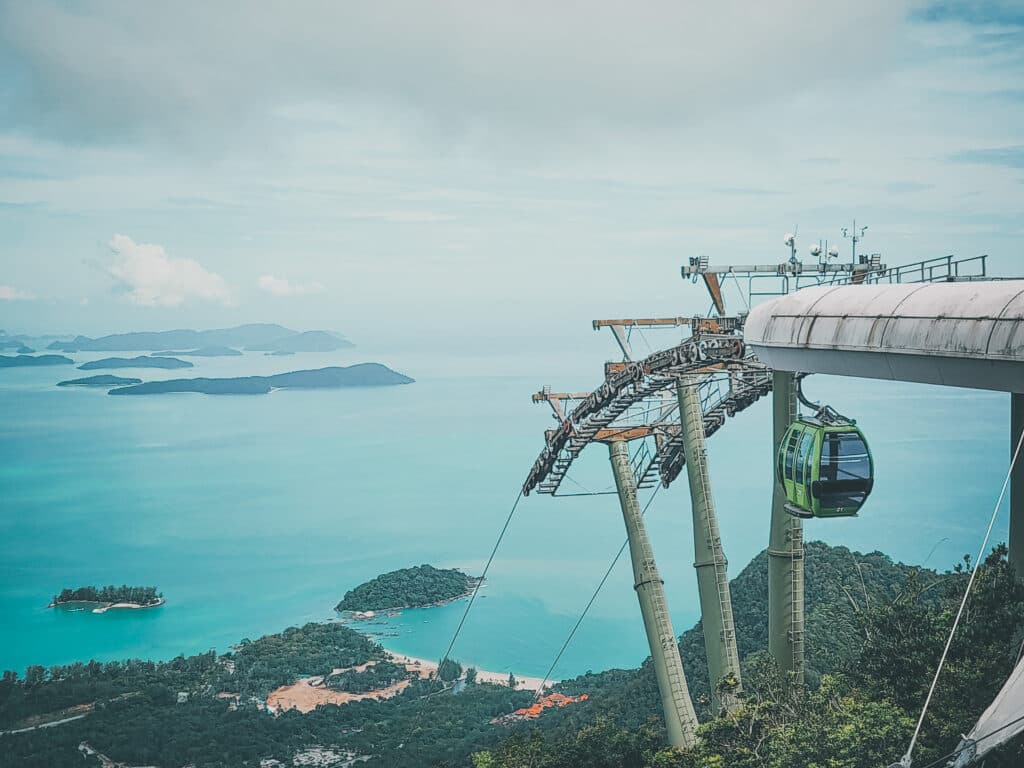 a cable car enters the top station of the langkawi skycab ride steep section of the track with Langkawi islands and the ocean in background