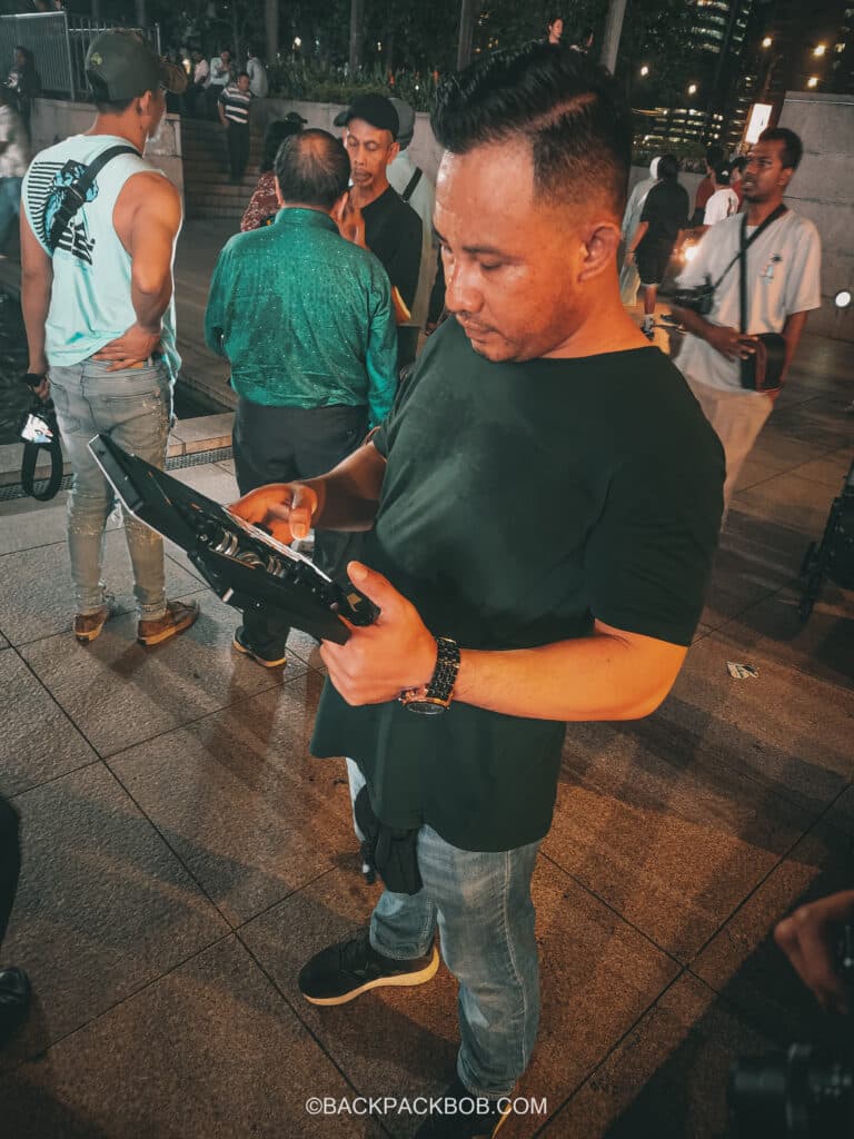 a tourguide selling photo services at kuala lumpur petronas towers