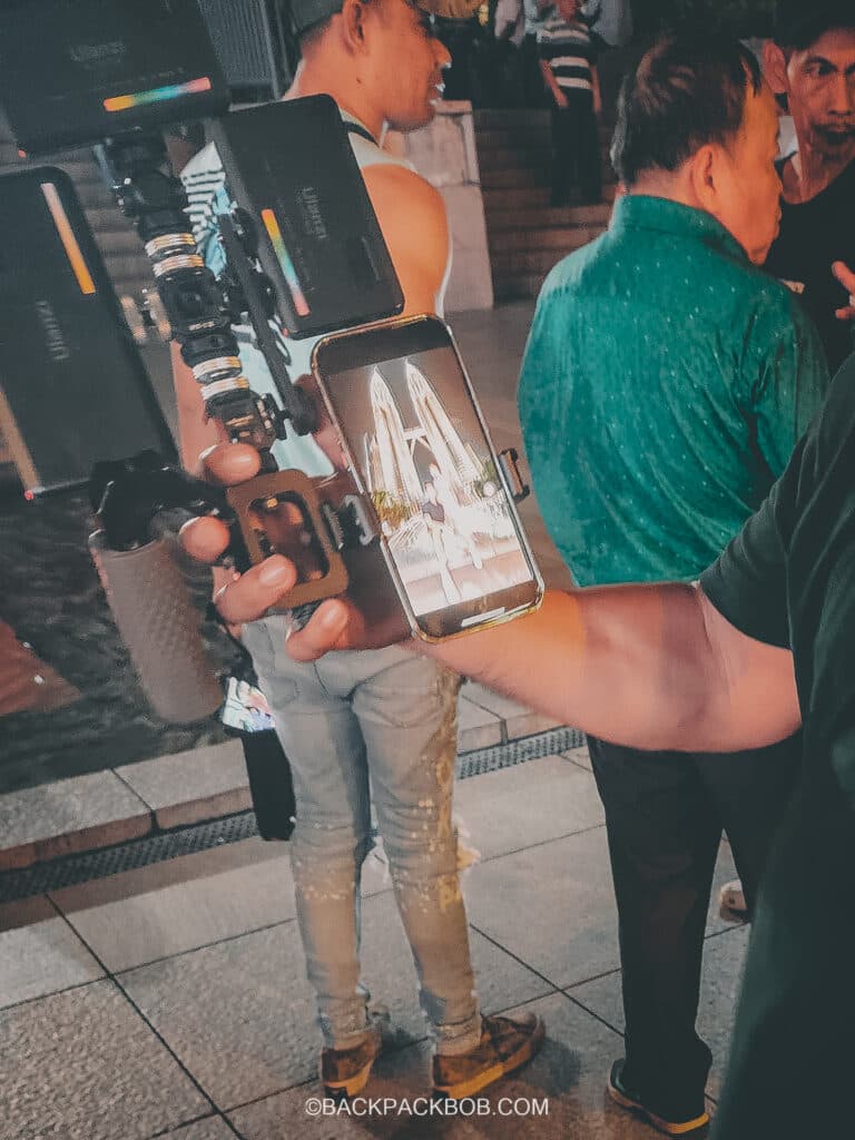 a tour guide showing his camera setup to photograph tourists visiting the Petronas Towers