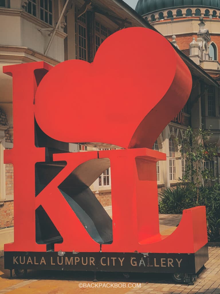 There is a red sign outside of the free gallery in Kuala Lumpur the sign has a love heart and the words I love Kuala Lumpur