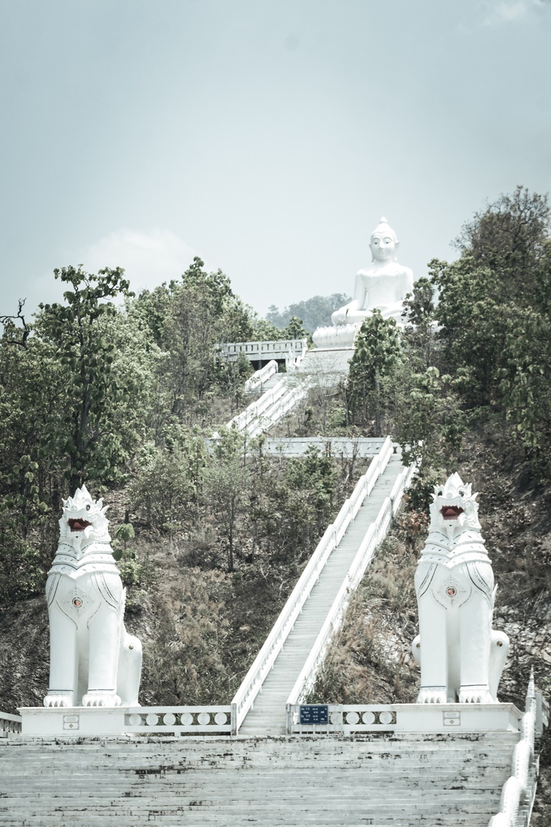 full height photo of pai big white buddha showing buddhist statue shrine and staircase full to the top