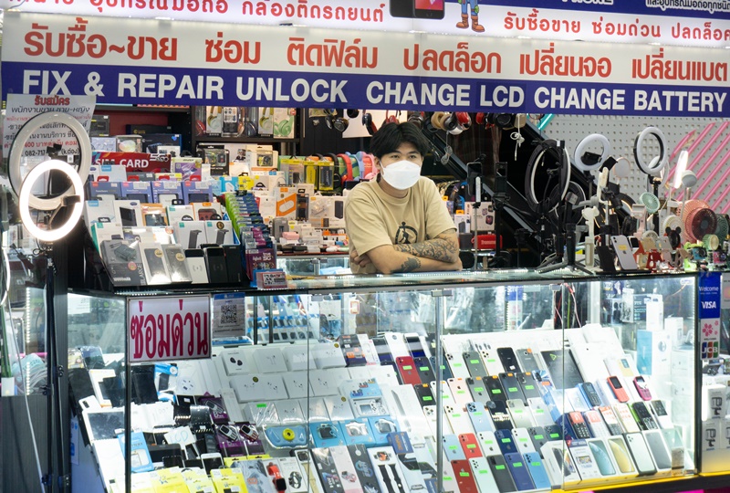 A mobile phone repair man behined his stall in the MBK shopping center