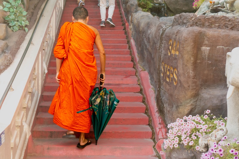 a Thai Monk at the Bangkok Temples walking upstairs