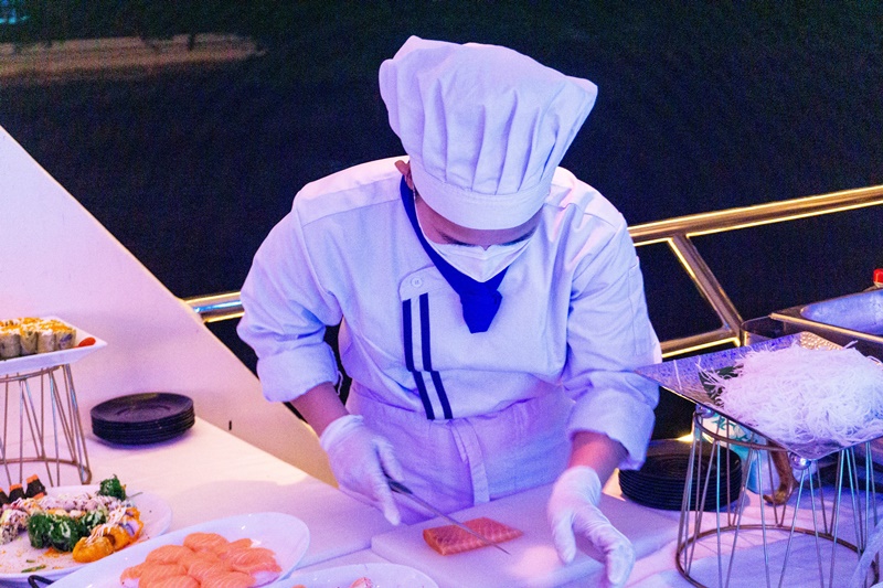 chef slicing sushi for guests on the princess bangkok dinner boat cruise