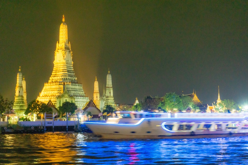 wat arun seen from the bangkok dinner cruise with boat passing by