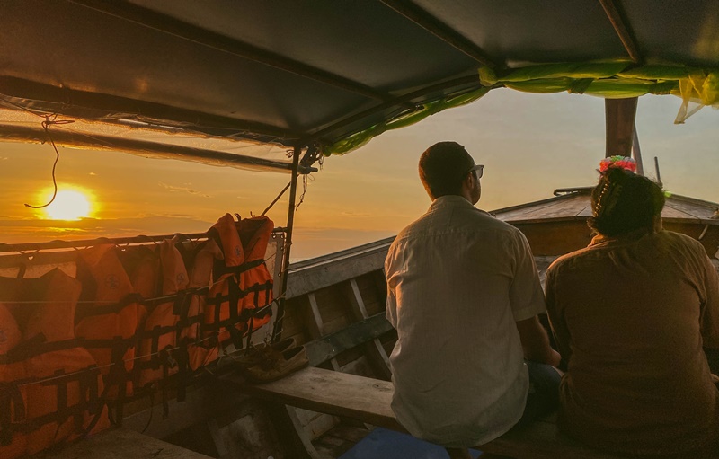 watching the sunset from a longtail boat at sea in the phi phi islands