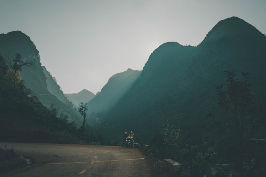 beautiful road on the vietnam ha giang loop motorbikes on tour stopping to admire the mountain valley sky view