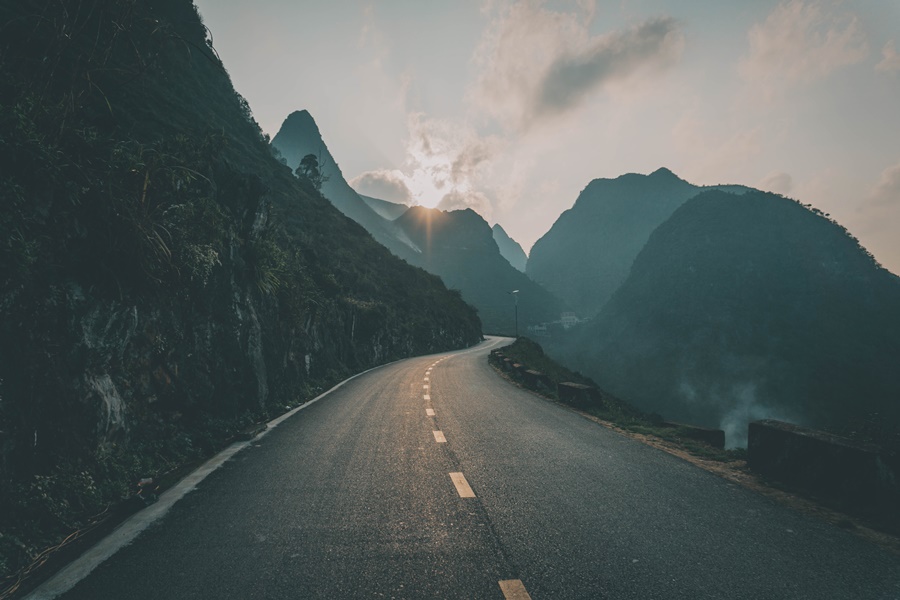 sunset on the ha giang loop as road winds through the mountains