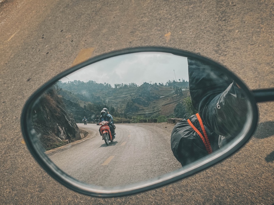 two people on one moterbike in ha giang loop vietnam from motorbike mirror