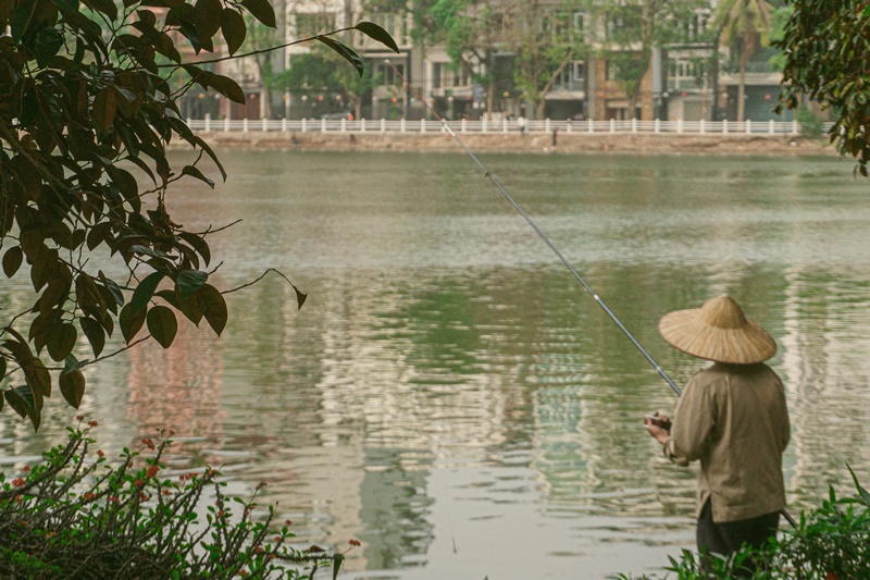what to do in Hanoi vietnam firsherman at the west lake tay ho photo