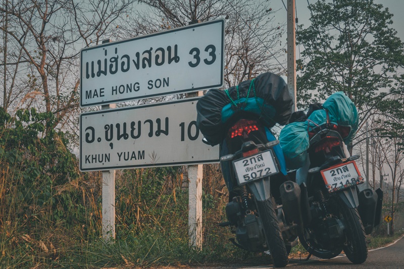 mae hong son loop road sign with parked motorbikes