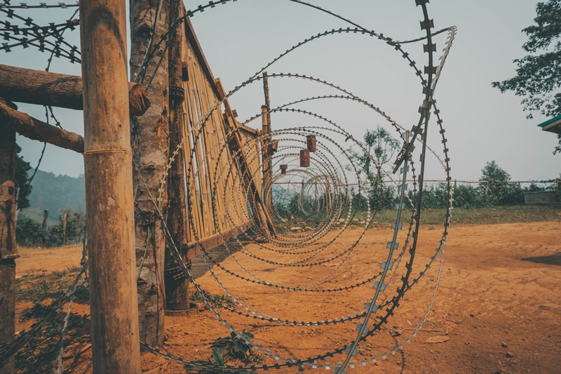 thi burmese border baan rak thai village barbed wire at land border crossing