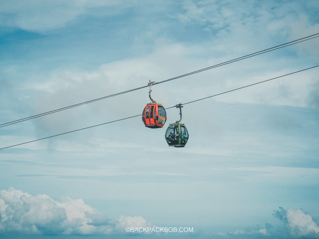 Two cable cars on the Langkawi skycab pass each other by. high in the sky above the clouds