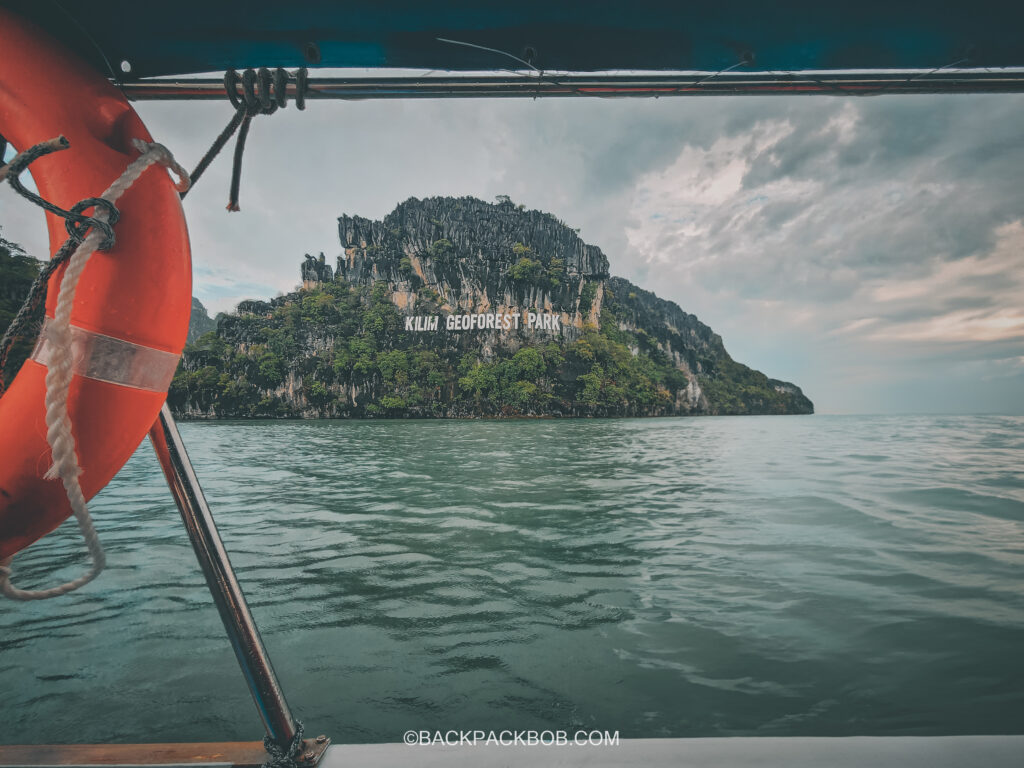 Kalim Geoforest Park the photo is taken from a boat cruising past and the sign is affixed on the cliff face