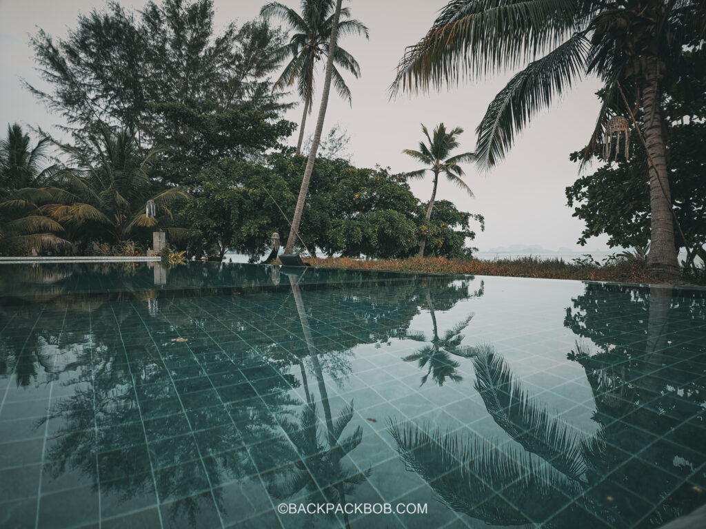 A photo of the outdoor swimming pool at Pawapi Beach Resort in Koh Mook, the swimming pool is surrounded by Palm trees