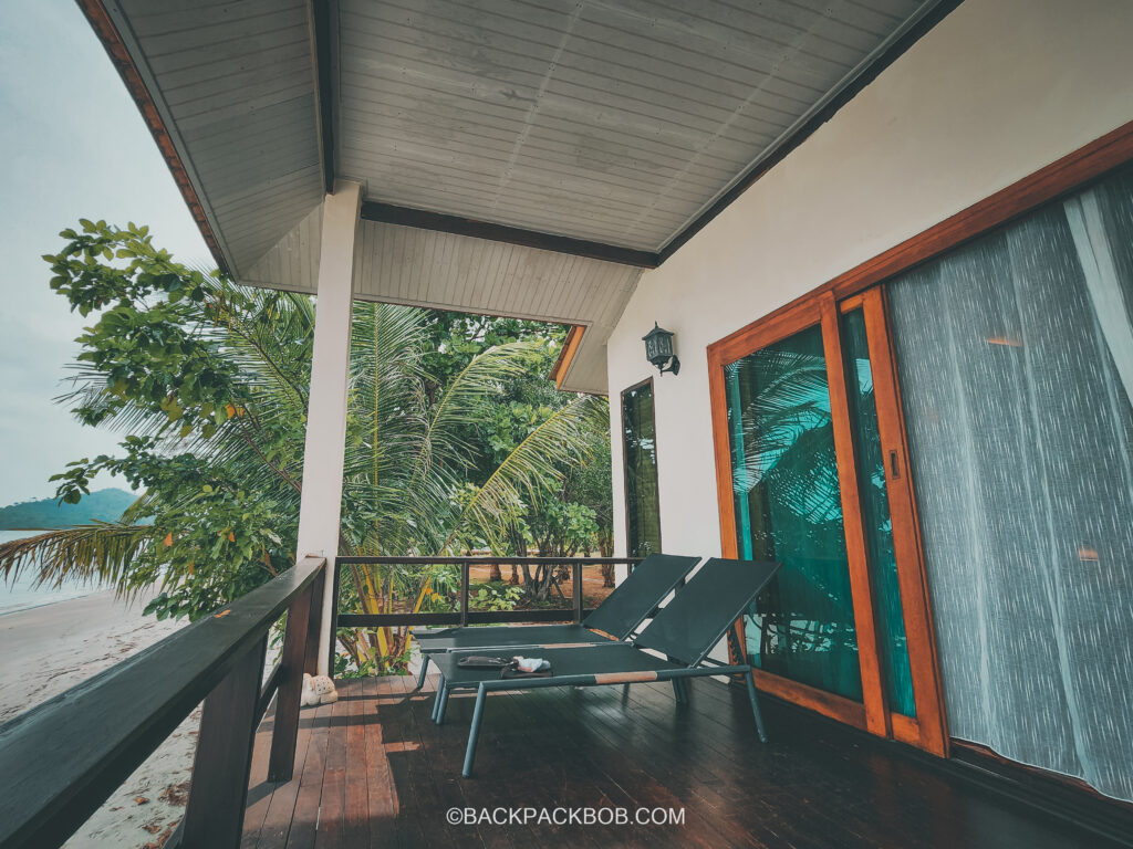 Balcony of villa room at Pawapi Beach Resort in Koh Mook there are 2 sun loungers on the porch looking out to sea