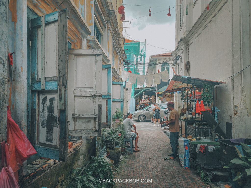 Malaysian narrow street in Ipoh, local men have a conversation