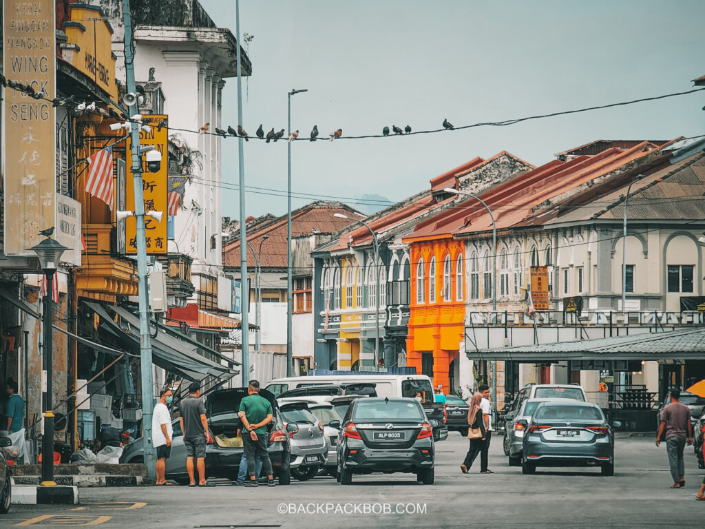 Street photography of locals in Ipoh, colorful houses and shop fronts on quiet street