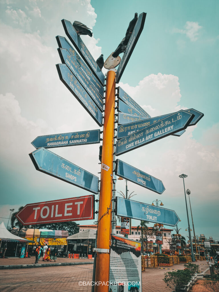A signpost at the Batu Caves, lists the best things to do at Batu Caves and which direction each attraction or Batu cave is located