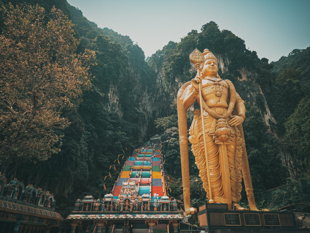 A panoramic photo of the lord murugan Kartikeya statue and the rainbow stairs and the Batu Caves in Kuala Lumpur