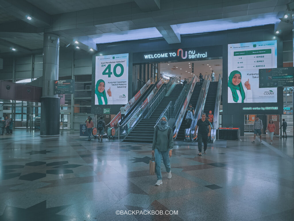 A Photo of the interior of KL Sentral Station, the signpost points to the KLIA Express departure area and the escalators can be seen, the entrance to the bus terminal