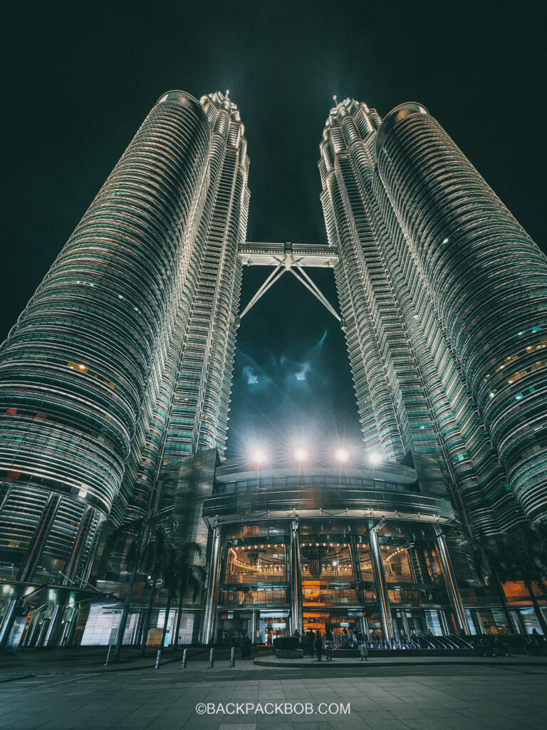 the Kuala Lumpur petronas towers photo taken from the ground floor and includes both towers and the lobby entrance