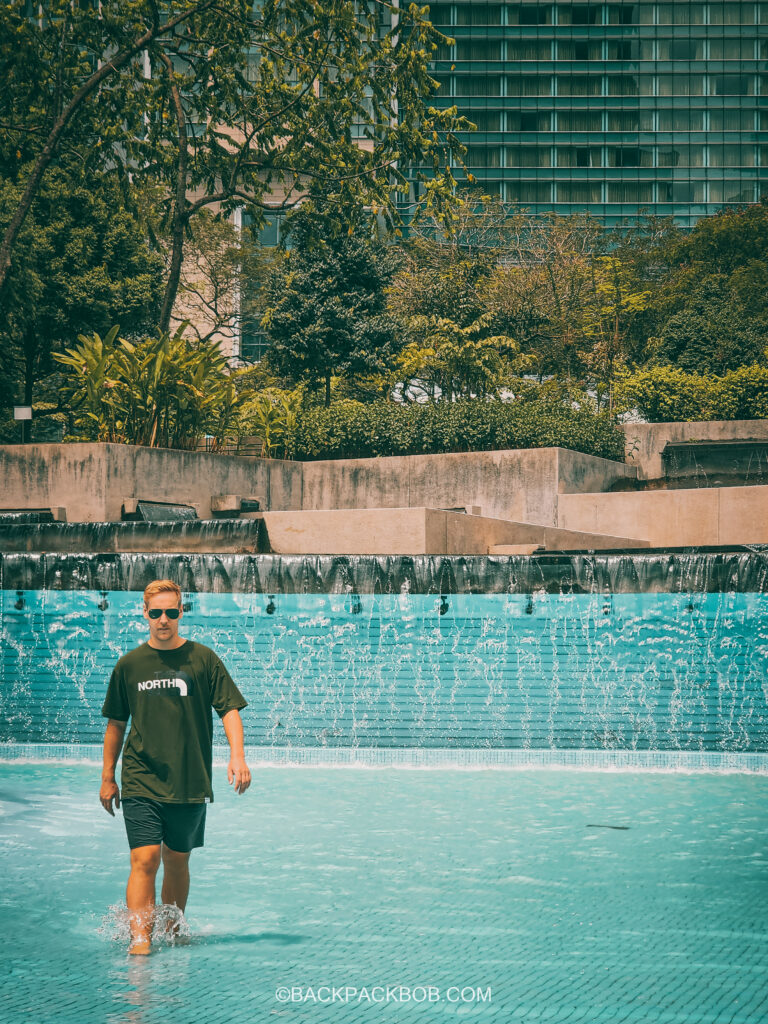 A photo of Backpack Bob in the KLCC Center waterfall park which is free to visit