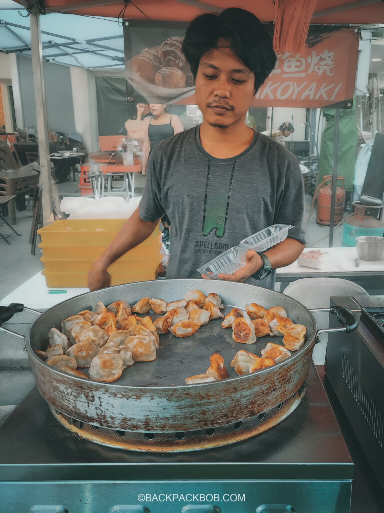 A seller at the Kuala Lumpur free market sells fried dumplings