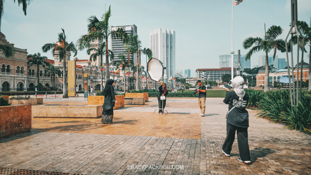 Malaysian Tourists set up a professional photo shoot, for free, outside the Kuala Lumpur Medeka Square 