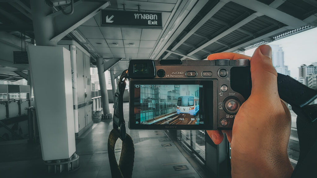 A tourist on the BTS Skytrain network is taking photos of the Skytrain on a digital camera