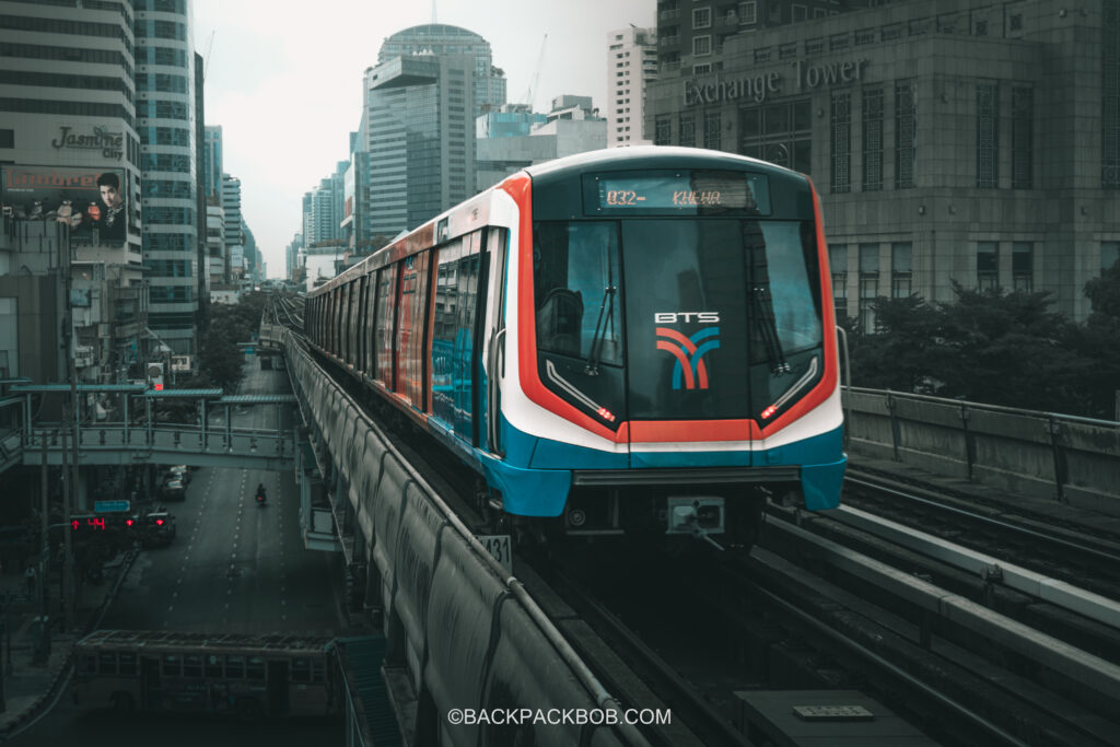 Eye catching dark photo of modern BTS Skytrain driving on elevated tracks in Bangkok near Asok Station