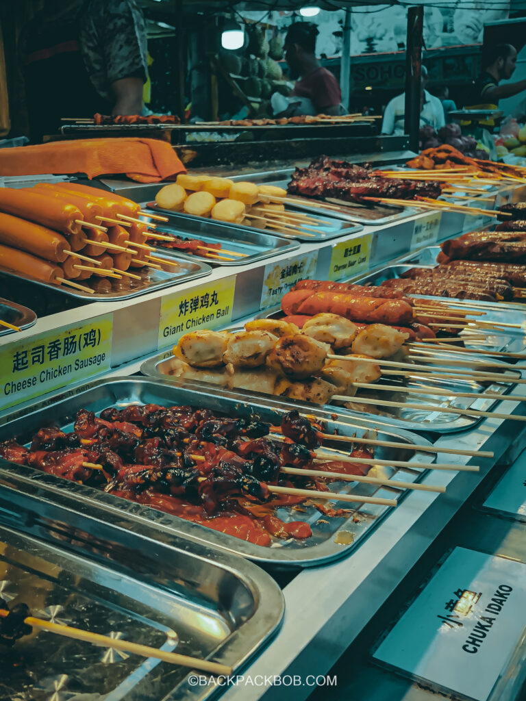 Jalan Alor Street Food Market in Kuala Lumpur, the market is free to visit but in this photo there are chesses and chicken and sausage skewers for sale