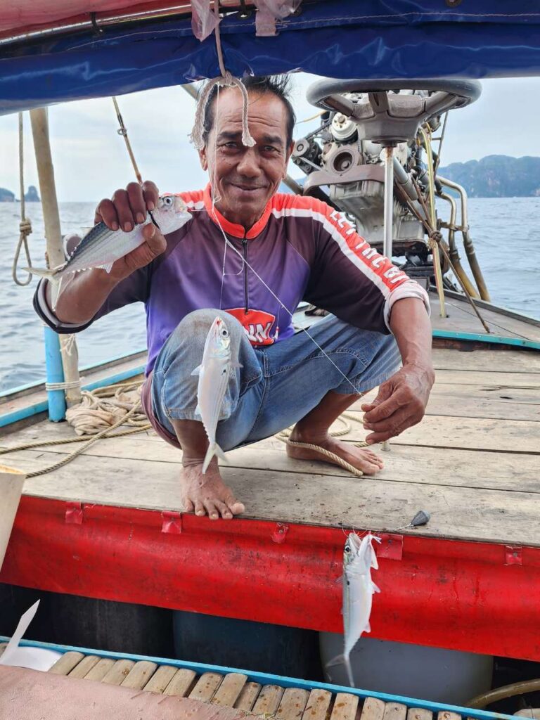 longtail boat captian with fish in koh phi phi boat